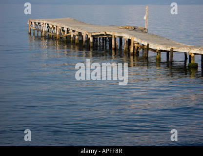 Un molo vuoto in legno che si proietta nell'Adriatico a Messongi, Corfù, in una tranquilla giornata estiva Foto Stock