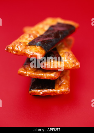 Pila di quattro cracker giapponese luminoso su sfondo rosso Foto Stock