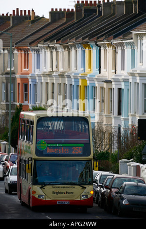 A Brighton e Hove autobus che passa una fila di colorfull casa a schiera a Brighton foto da James Boardman Foto Stock