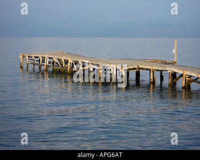 Un molo vuoto in legno che si proietta nell'Adriatico a Messongi, Corfù, in una tranquilla giornata estiva Foto Stock