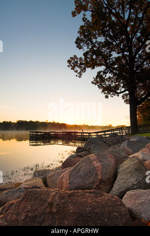 Alba sul lago Hyland in Bloomington Minnesota dalla costa rocciosa con dock di pesca e nebbia Foto Stock