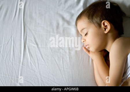 Colore della testa e spalle ritratto di piccolo ragazzo giovane di età compresa tra i tre dormire serenamente Foto Stock