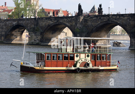 Una barca di legno passa nella parte anteriore del Ponte Carlo, il fiume Vltava, Praga, Repubblica Ceca, Europa Foto Stock