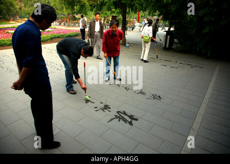 Calligraphy master dando lezioni pubbliche in un parco di Pechino. Foto Stock