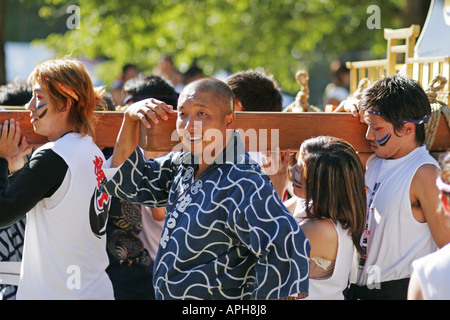 Il popolo giapponese che trasportano un mikoshi santuario portatile sulle loro spalle Foto Stock