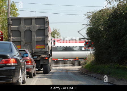 Il traffico in attesa presso un passaggio a livello ferroviario come una vergine la velocità del treno attraverso in Inghilterra Foto Stock