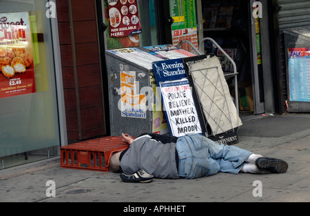 Senzatetto uomo addormentato in un vano della porta del negozio nella zona est di Londra. Foto Stock