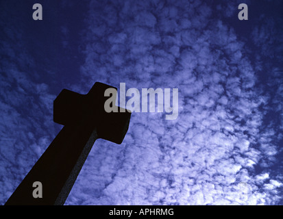 Una croce di un oggetto contrassegnato per la rimozione definitiva in un cimitero contro un blu cielo sgombro Foto Stock