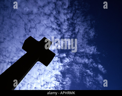 Una croce di un oggetto contrassegnato per la rimozione definitiva in un cimitero contro un mackeral blu cielo Foto Stock