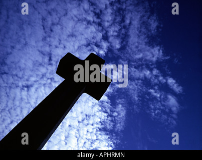 Una croce di un oggetto contrassegnato per la rimozione definitiva in un cimitero contro un blu cielo sgombro Foto Stock