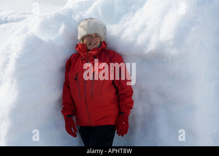 Di mezza età turismo avventura in tempo freddo marcia in piedi da un snow drift in Antartide Foto Stock