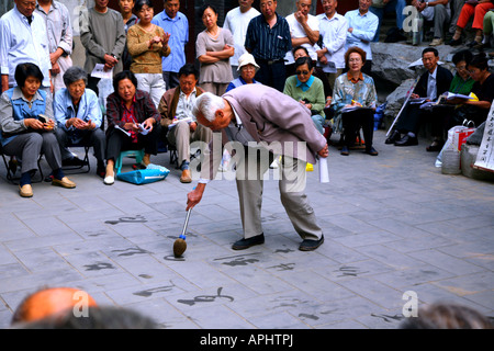 Calligraphy master dando lezioni pubbliche in un parco di Pechino. Foto Stock