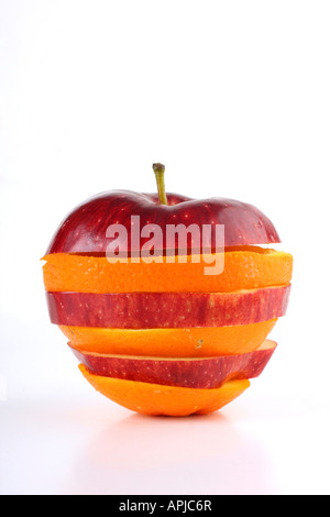Fette di un apple e orange messi insieme per formare un ibrido frutto girato in bianco in un studio Foto Stock