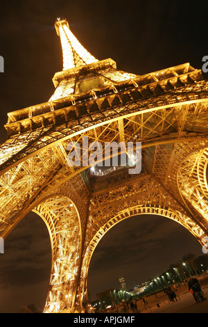 Torre Eiffel Tour di Parigi illuminata di notte la base close up Foto Stock