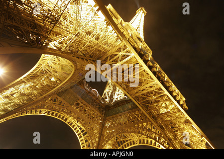 Torre Eiffel Tour di Parigi illuminata di notte la base close up Foto Stock