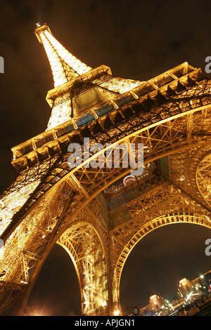 Torre Eiffel Tour di Parigi illuminata di notte la base close up Foto Stock