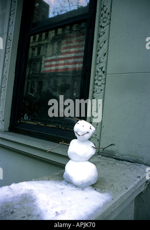 Mini pupazzo di neve sulla parete a New York a stelle e strisce della bandiera nella finestra Foto Stock