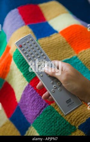 Donna che mantiene il controllo remoto per la televisione Foto Stock