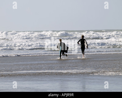 Coppia giovane in esecuzione nel mare con bodyboards. Foto Stock