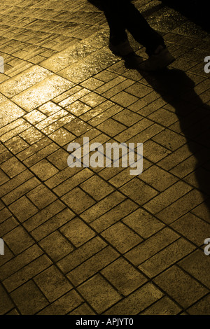 Una strada marciapiede in sunset con ombra. Nessun modello di rilascio richiesto comp rende la persona irriconoscibile Foto Stock