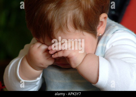 Sleepy Baby girl strofinando gli occhi Foto Stock