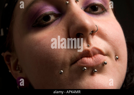 In prossimità della faccia del giovane donna gallese con più piercing nel naso e labbra Foto Stock