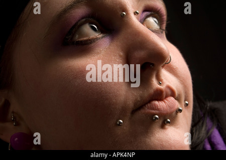 Close up del volto di una giovane chubby welsh la donna con più piercing nel naso e labbra Foto Stock
