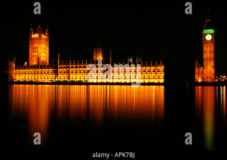 Le case del Parlamento oro incandescente con un nero cielo notturno, riflettendo in un buon fiume Tamigi Foto Stock