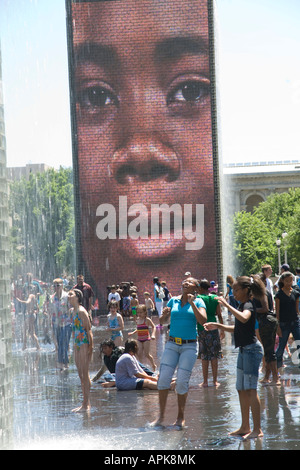 ILLINOIS Chicago adulti e bambini giocare in acqua dalla fontana di corona in Millennium Park faccia sul grande schermo video Foto Stock