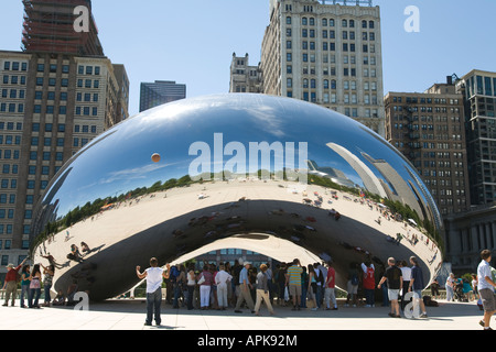 ILLINOIS Chicago Boy gettando la pallacanestro in aria accanto a fagiolo Cloud Gate sculpture Millennium Park edifici della città Foto Stock