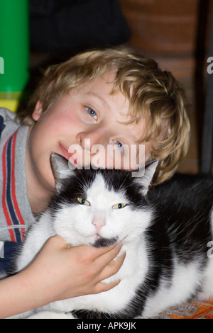 Bambino con in bianco e nero gatto domestico Foto Stock