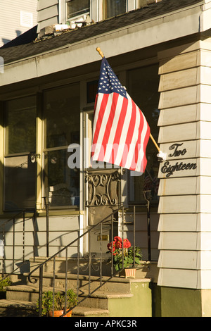 ILLINOIS Dixon bandiera americana appesa per porta a middle class house geranio sul passo anteriore Foto Stock