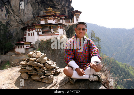 Il Bhutan Tigri Taktsang Nest monastero con bhutanesi uomo seduto davanti Foto Stock