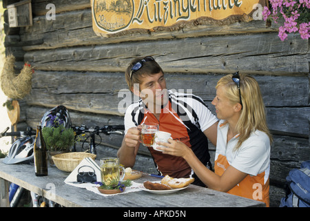 Giovani mountain biker matura per mangiare in un rifugio alpino Foto Stock