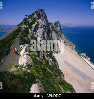 Giovane camminando lungo il sentiero sul punto più alto della Rocca di Gibilterra con la costa della Spagna in background Gibilterra Foto Stock
