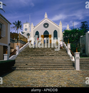 Le persone sulla scalinata che conduce fino al colorato di bianco la chiesa di San Pietro con la torre dell orologio contro il cielo blu Bermuda Foto Stock