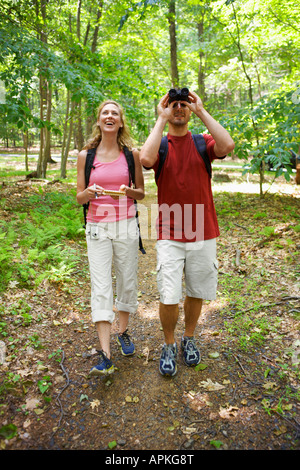 L uomo e la donna a guardare gli uccelli in foresta Foto Stock