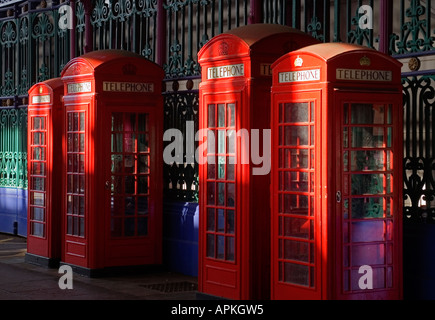 Fila di quattro tradizionali telefono rosso scatole, città di Londra, Regno Unito Foto Stock