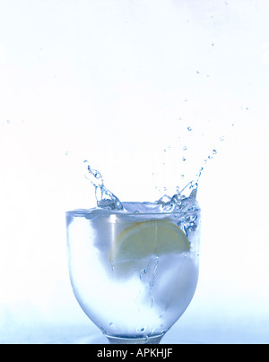 Il cubo di ghiaccio schizzi in un bicchiere di acqua Foto Stock