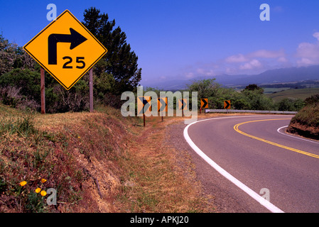 Il limite massimo di velocità su strada di avvertimento di segno i conducenti di Sharp curva a destra lungo la Pacific Coast Highway 1, CALIFORNIA, STATI UNITI D'AMERICA Foto Stock