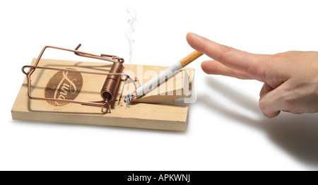 Dita femmina di intrufolarsi di fumare una sigaretta in un mousetrap Foto Stock
