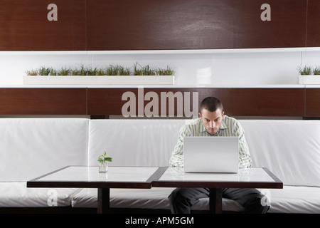 Uomo che utilizza il computer portatile sulla tabella di caffè Foto Stock