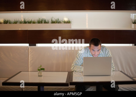 Uomo che utilizza il computer portatile sulla tabella di caffè Foto Stock