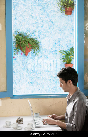Uomo che utilizza il computer in café Foto Stock
