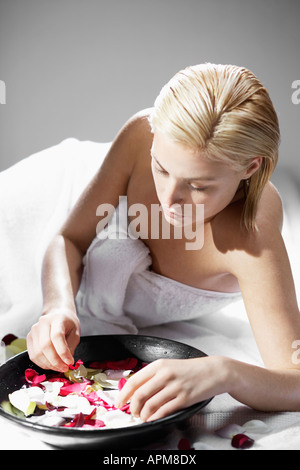 Giovane donna con ciotola di acqua di rose Foto Stock