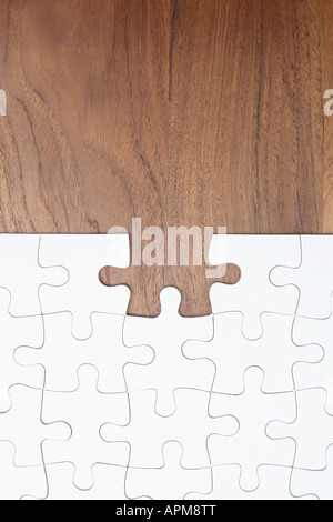 Puzzle su sfondo di legno e un pezzo mancante Foto Stock