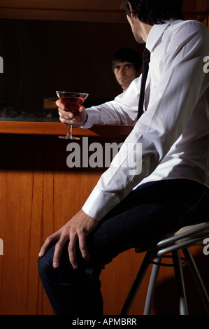 Uomo con un drink in un bar Foto Stock