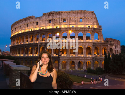 Donna al telefono cellulare di fronte al Colosseo Roma Italia Foto Stock