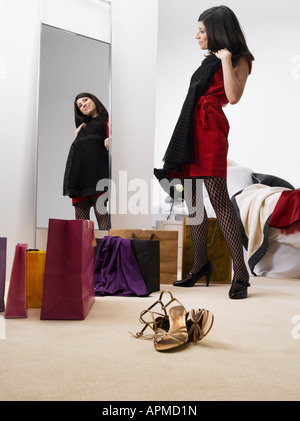 Giovane donna cercando vestiti sul vicino a specchio, a basso angolo di visione Foto Stock