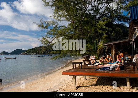 Giovani tan su beach bar sun deck Ko Tao Thailandia Foto Stock